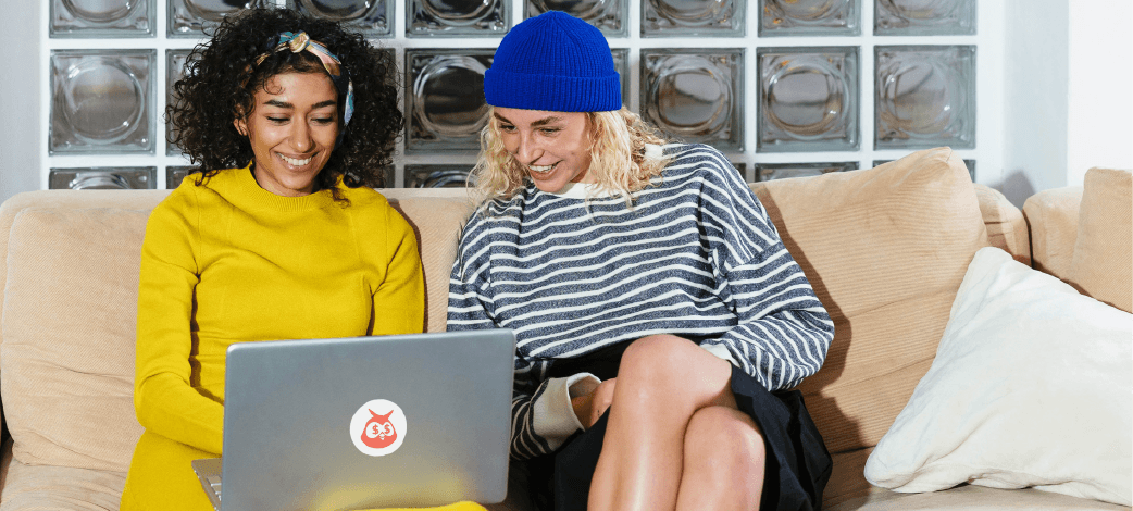 Two people sitting in front of a laptop, with the Hoot Suite Owl logo on the front of the laptop.